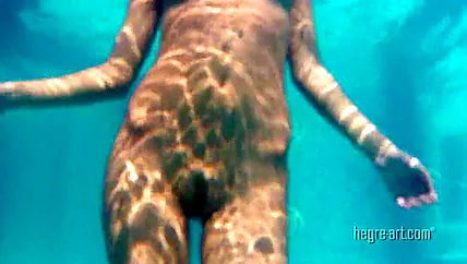 Голая сучка с интимной стрижкой позирует под водой и на пляже